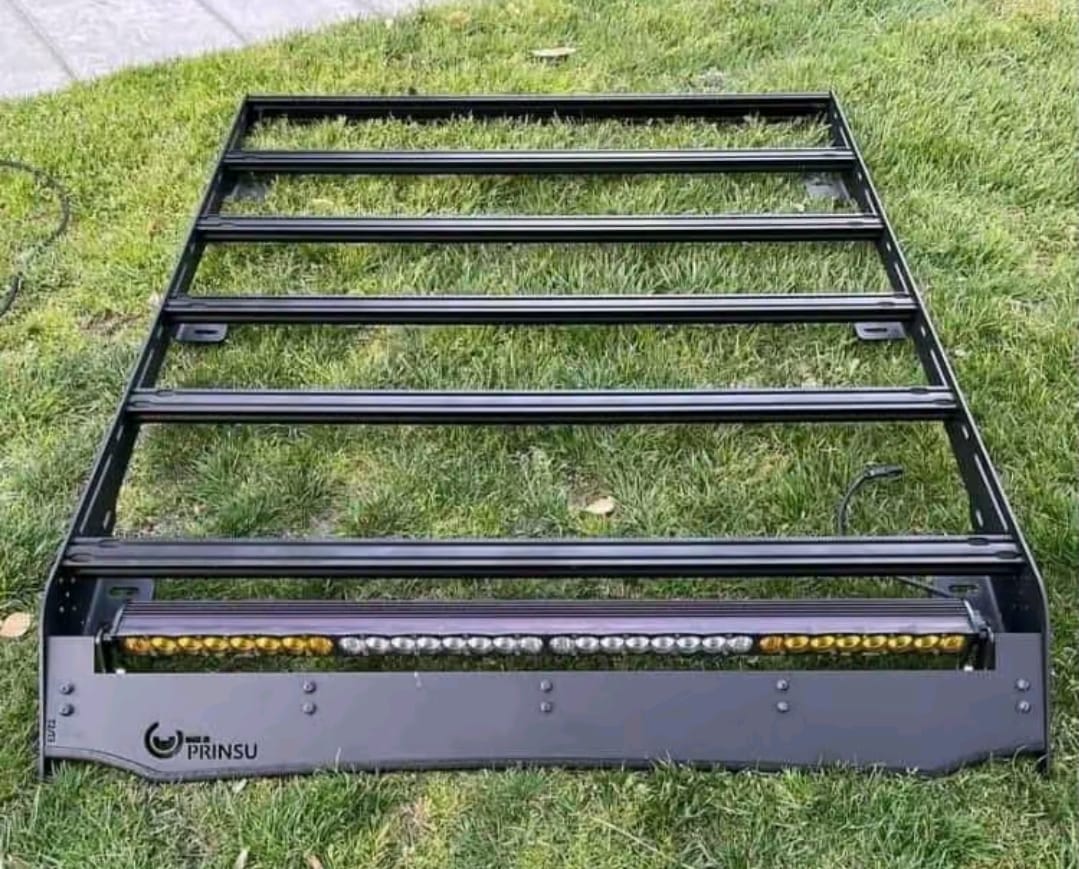 Toyota Tacoma roof rack mounted on pickup truck for cargo and outdoor gear, Toyota Tacoma aluminum roof rack with full-length platform, Toyota Tacoma low-profile roof rack with crossbars, Toyota Tacoma heavy-duty off-road roof rack for overlanding, Toyota Tacoma premium modular roof rack with accessory mounting points, Toyota Tacoma roof rack with LED light bar and cargo platform, Toyota Tacoma factory-style roof rack for camping equipment, Toyota Tacoma roof cargo rack installed on double cab pickup, Toyota Tacoma black powder-coated roof rack for outdoor adventures, Toyota Tacoma expedition roof rack with modular platform design,